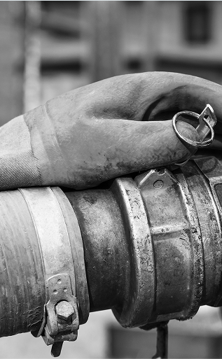 Gloved hand connecting water hose to utility hook up.